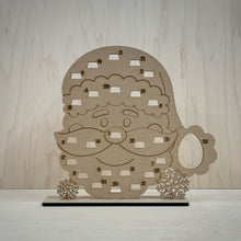Load image into Gallery viewer, Freestanding MDF Santa's Face Advent calendar on a wooden background.