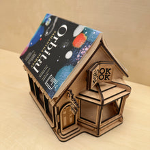 Load image into Gallery viewer, A top down view of a wooden model of a bookshop engraved with the name "The Book Nook" on the sign, with an open book on top.