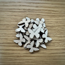 Load image into Gallery viewer, A pile of twenty wooden laser cut blank butterfly shapes. Items laid out on a darker wooden background.