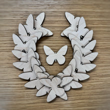 Load image into Gallery viewer, A group of twenty wooden laser cut blank butterfly shapes. Items laid out on a darker wooden background.