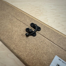 Load image into Gallery viewer, A close up of a rectangular MDF jewellery box with a small black metal clasp, a hinged bevelled lid and a white barcode label, set on a light wood grain surface.