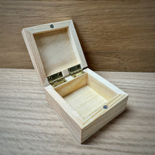 Load image into Gallery viewer, A small blank wooden keepsake box with an open lid, showing brass hinges and a magnetic clasp in a light natural wood, placed on a darker wooden surface.