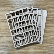 Load image into Gallery viewer, A miniature wooden laser cut tray divided into sections to mimic the old type setter trays. The layers are fanned out on a wooden background.