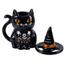 Load image into Gallery viewer, Black cat-shaped mug with a witch hat lit on a white background. Item has orange eyes on the cat and an orange stripe on the hat. White whiskers and floral patterns are on the cat too.