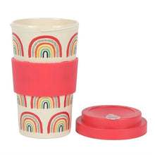 Load image into Gallery viewer, A reusable travel tumbler with a cream-coloured body printed with colourful rainbow patterns. Its red lid is next to the tumbler and has a matching red silicone grip band in the middle of the cup. Item on a white background.