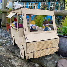 Load image into Gallery viewer, The front of a 3D laser cut food truck cupcake stand made in MDF. Item has knitted gnomes and other items for display and is photographed on a stone wall in a garden.