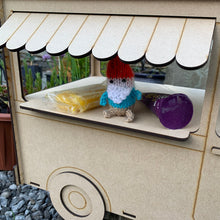 Load image into Gallery viewer, A close up of the window for a 3D laser cut food truck shaped cupcake stand. An awning, door handle and wheel is layered. A knitted gnome and other items are in the window on the inside shelf for display.