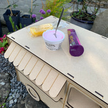 Load image into Gallery viewer, The back end of the roof and window awning for a 3D laser cut food truck cupcake stand. A few kinds of ice creams and push pops are resting on the roof shelf to show its size and function as a display stand.