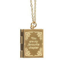 Load image into Gallery viewer, A gold-toned book-shaped pendant necklace with 'You are my favourite chapter' text and floral corner embellishments engraved on the locket's front cover. The gold chain hangs from a ring and loop attached to the locket. Item on a white background.
