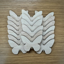 Load image into Gallery viewer, A group of twenty wooden laser cut blank butterfly shapes. Items laid out on a darker wooden background.
