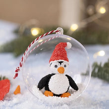 Load image into Gallery viewer, A clear plastic bauble with an example clay penguin in a santa hat to show that the bauble can be filled with decorations.
