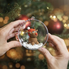 Load image into Gallery viewer, Two hands holding a clear plastic bauble with an example clay reindeer inside to show that the bauble can be filled with decorations and other tiny crafts.
