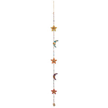 Load image into Gallery viewer, Decorative fabric star and moon hanging with beads and a small bell at the end on a white background.
