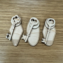 Load image into Gallery viewer, Three laser-cut sets of wooden key &amp; keyring shapes, displayed on a wood grain surface.
