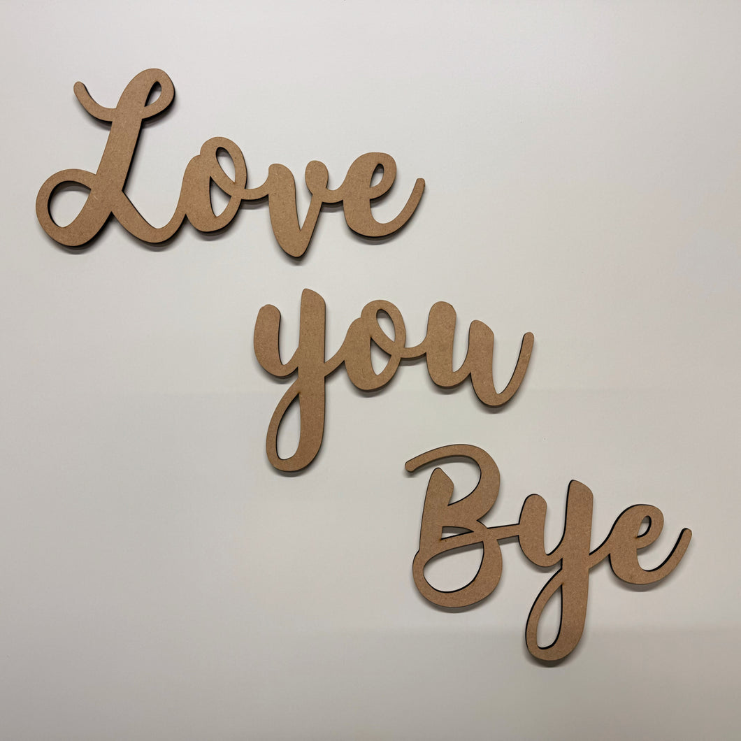 Wooden cutout letters spelling 'Love you Bye' on a light background
