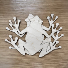 Load image into Gallery viewer, Two larger wooden laser cut frog shapes on a wood surface.
