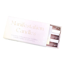 Load image into Gallery viewer, A matchbox-style box of 'Manifestation Candles' with three pink candles partially slid out. The box is pale pink with gold lettering and small star illustrations, shown on a white background.
