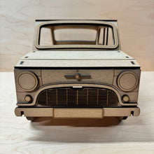Load image into Gallery viewer, The front of a 3D MDF laser cut cupcake stand in the shape of a classic mini car. Item has layered lights, bumpers, grill, logo and other parts. Item on a light wooden background. 
