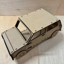 Load image into Gallery viewer, The top, detailed side, and back, of a 3D MDF laser cut cupcake stand in the shape of a classic mini car. Item has layered wheels, door hinges, door handle, and fuel cap. Item on a light wooden background. 
