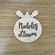 Load image into Gallery viewer, A wooden laser cut Christmas Pudding shape with the words "Nadolig Llawen" cut out on the body. Item on a wooden background.
