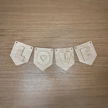 Load image into Gallery viewer, A wooden laser cut pennant shaped bunting, with two holes in the top corners, and rounded corners, plus a cute font layered on top spelling out "LOVE". Item laid out on a darker wooden surface.

