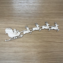 Load image into Gallery viewer, Wooden laser cut of Santa in sleigh with reindeer on a wooden surface
