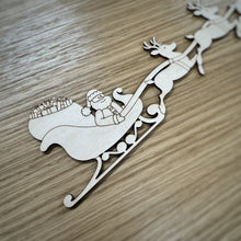 Load image into Gallery viewer, A close up of a wooden laser cut of Santa in sleigh with reindeer on a wooden surface
