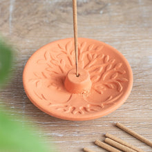 Load image into Gallery viewer, A terracotta incense stick holder with an embossed tree of life design, with a plain incense stick in the holder.
