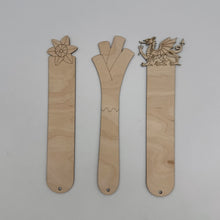 Load image into Gallery viewer, Three wooden bookmarks with engraved designs of a daffodil and a Welsh Dragon on top, and another shaped like a leek.
