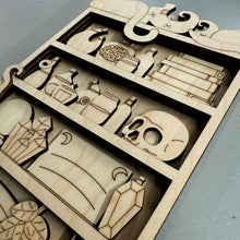 Load image into Gallery viewer, A close up photo of a laser cut kit of a witch's shelf with Books, Vials, Crystals, a skull, and other witchy items.
