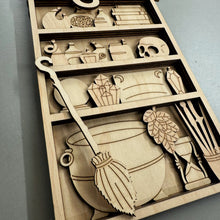 Load image into Gallery viewer, A close up photo of a laser cut kit of a witch's shelf with a broom, Cauldron, Vials, Crystals, a skull, wands, and other witchy items.
