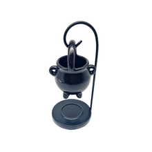 Load image into Gallery viewer, A Ceramic black cauldron-shaped tealight oil/wax burner with a metal hanging stand. Image on a white background.
