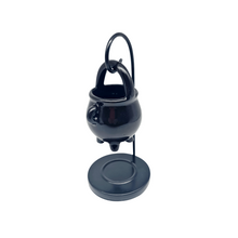 Load image into Gallery viewer, A Ceramic black cauldron-shaped tealight oil/wax burner with a metal hanging stand. Image on a white background.
