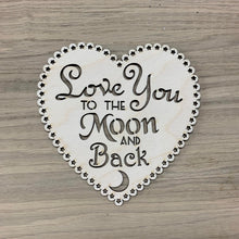 Load image into Gallery viewer, A wooden laser cut scalloped heart with tiny alternating hearts and stars cut out of each scallop bump. The phrase "Love You To The Moon And Back" is cut out in various types of font in the centre of the heart plaque. A small crescent moon shape is cut out of the bottom of the heart underneath the phrase.
