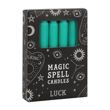 Load image into Gallery viewer, A pack of 12 black Magic Spell Candles in a black cardboard box with a witch themed pattern and the word "Luck" at the bottom. The green candles can be seen in a cut out window in the packaging. Item on a white background.
